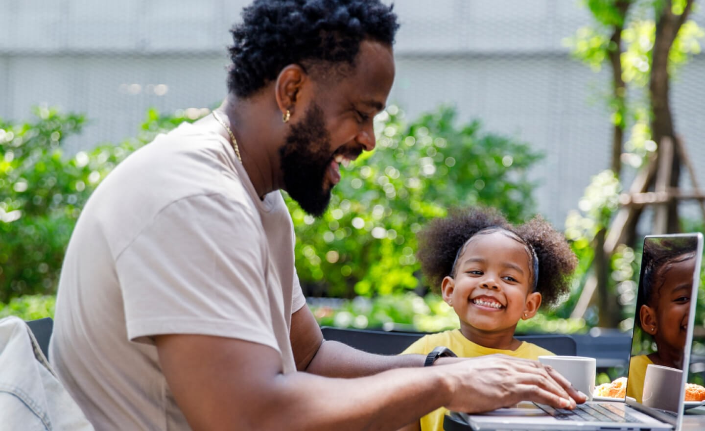 Father working from home in backyard with daughter 720x440