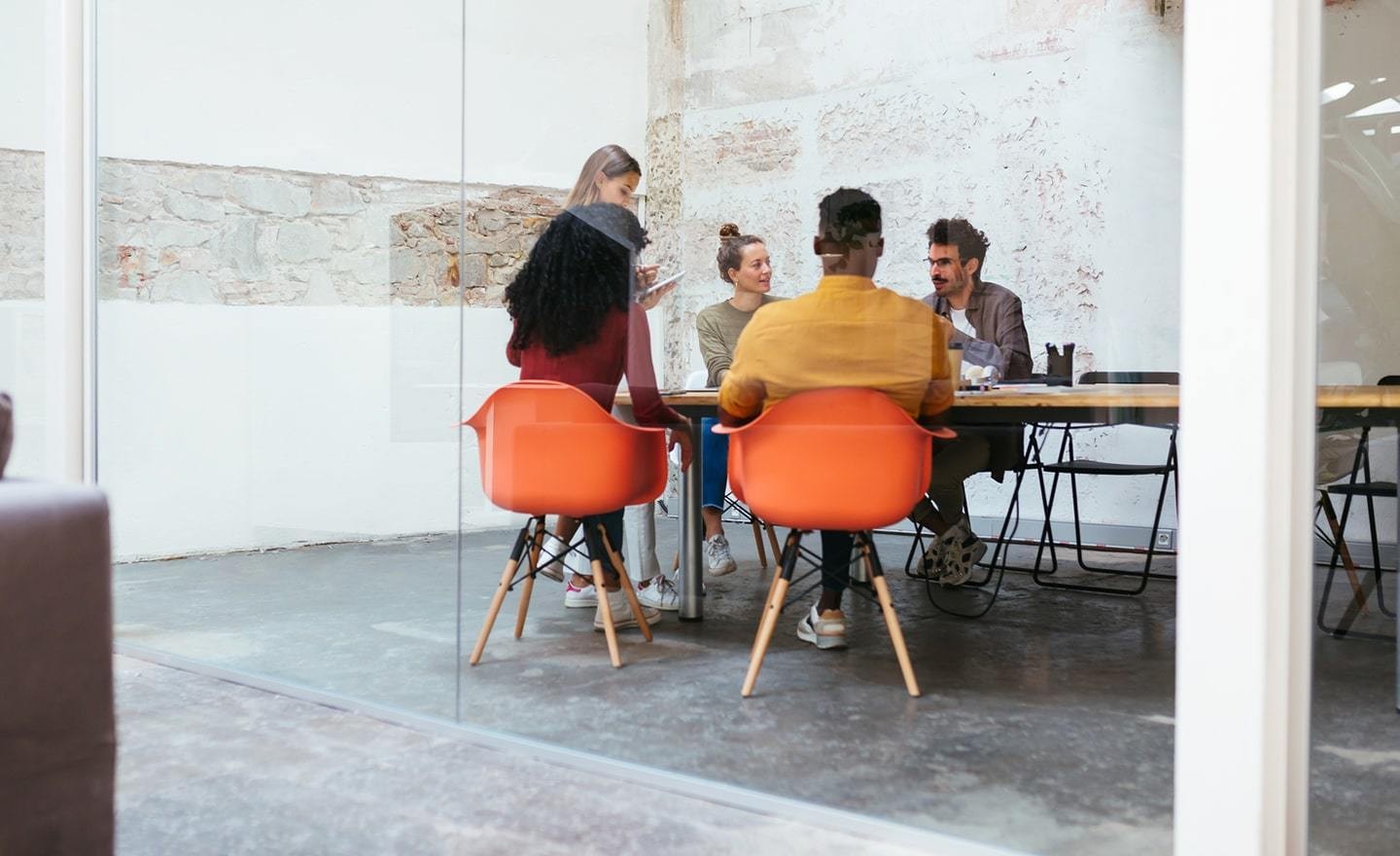 Group of people in a conference room seen through glass