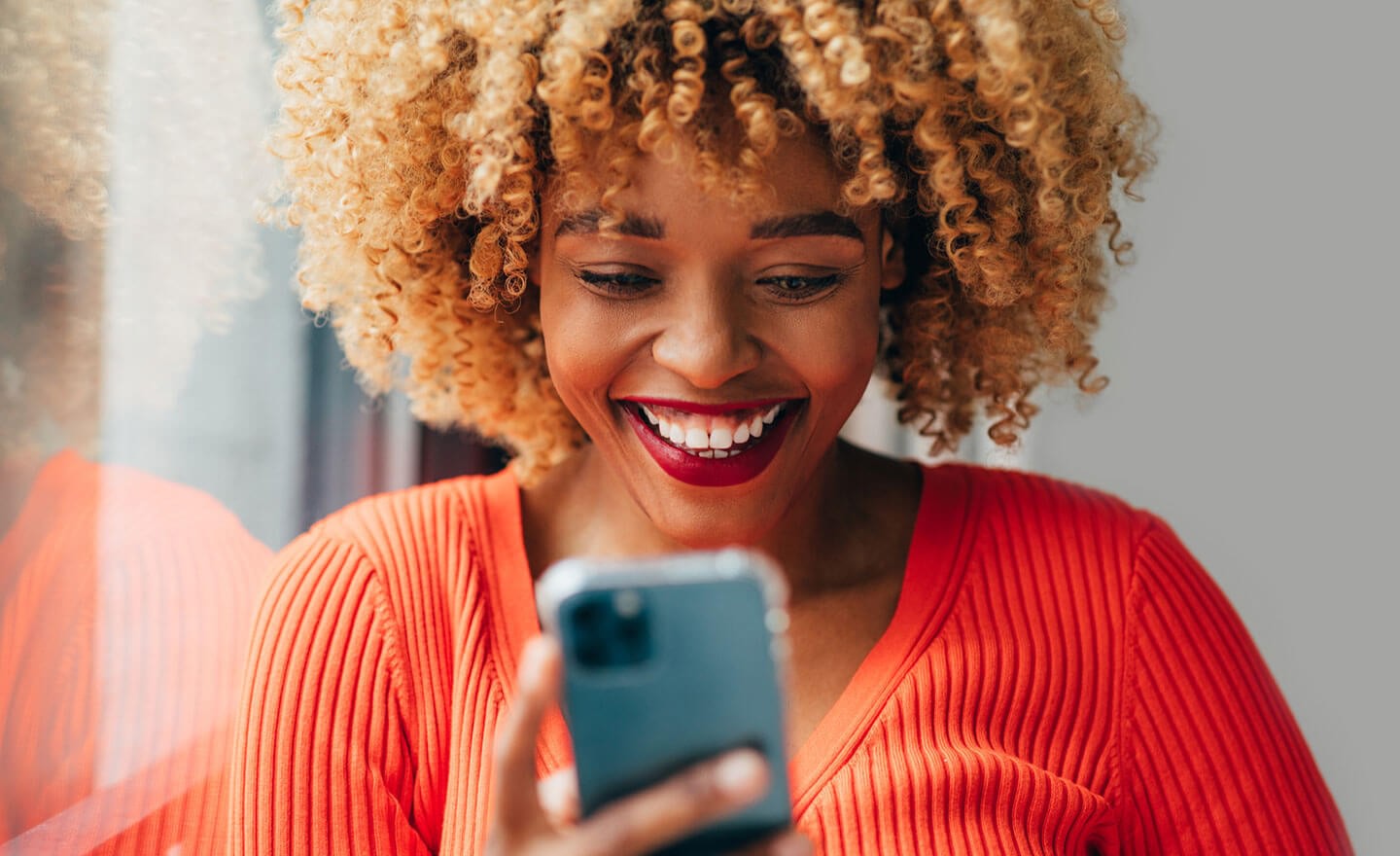 Happy woman reading email on phone