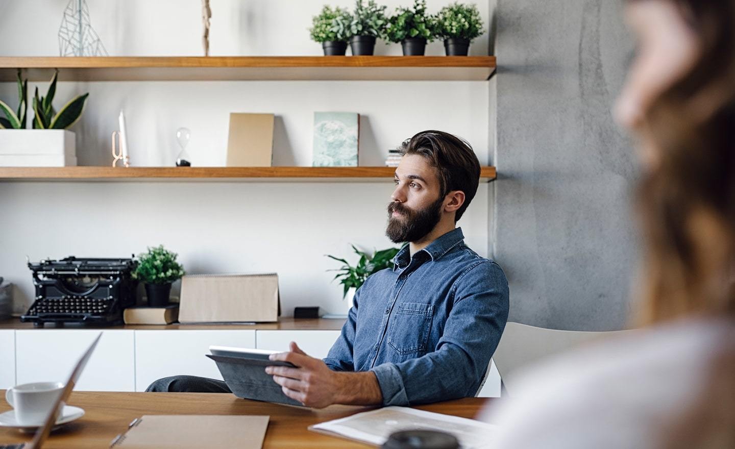 Man taking notes on tablet in meeting