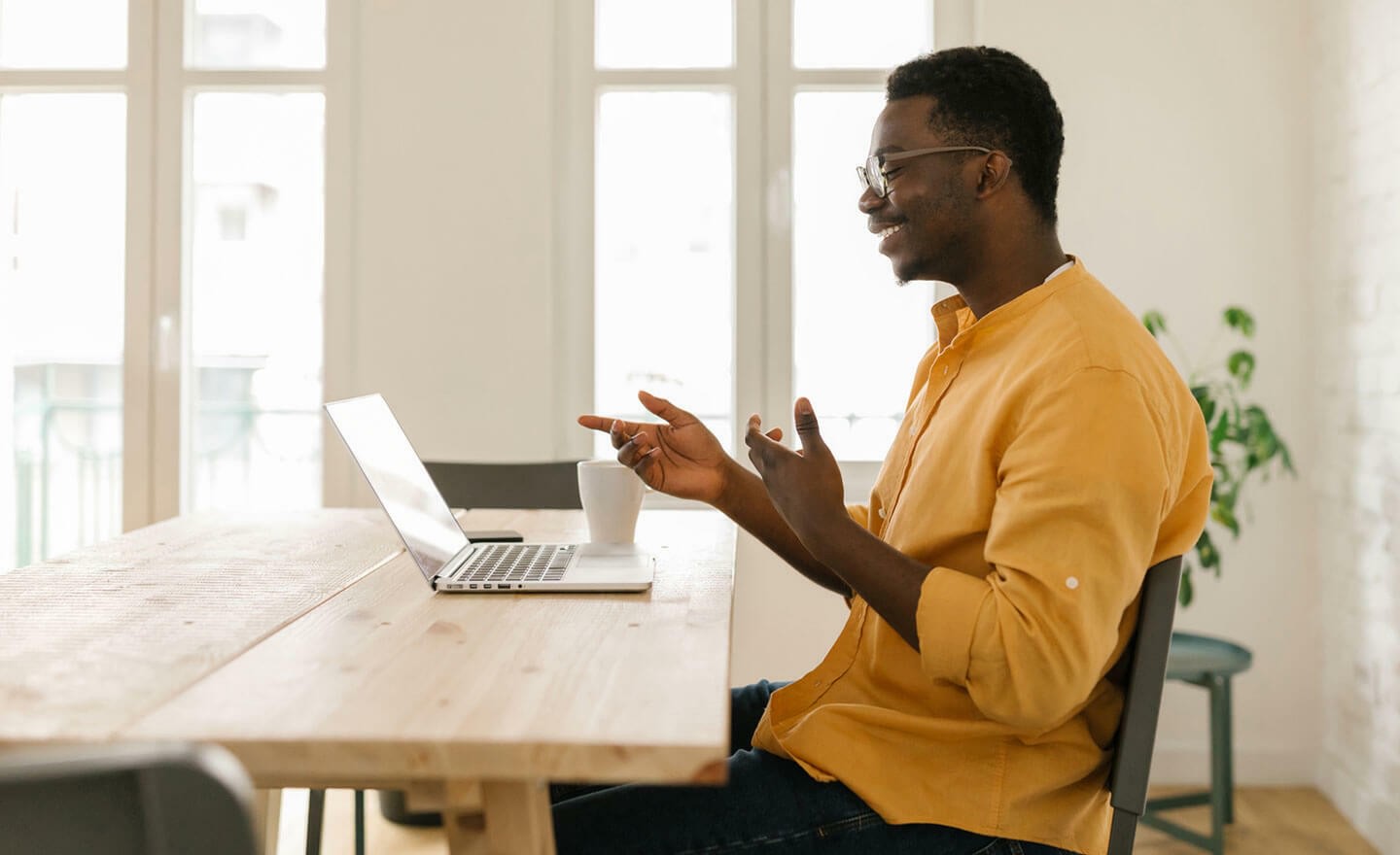 Person talking to coworker on laptop video meeting