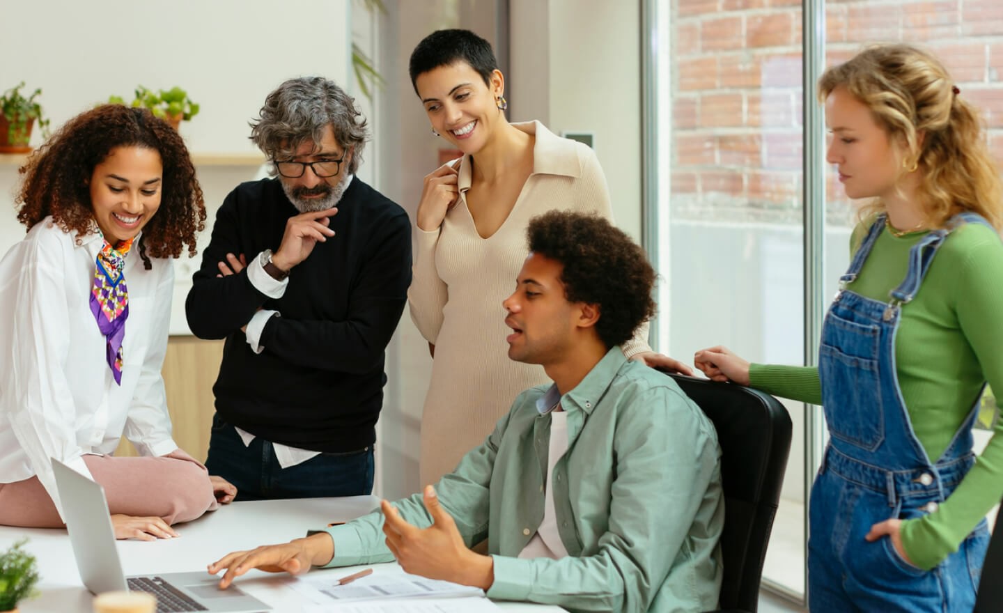 Team reviewing work on computer together