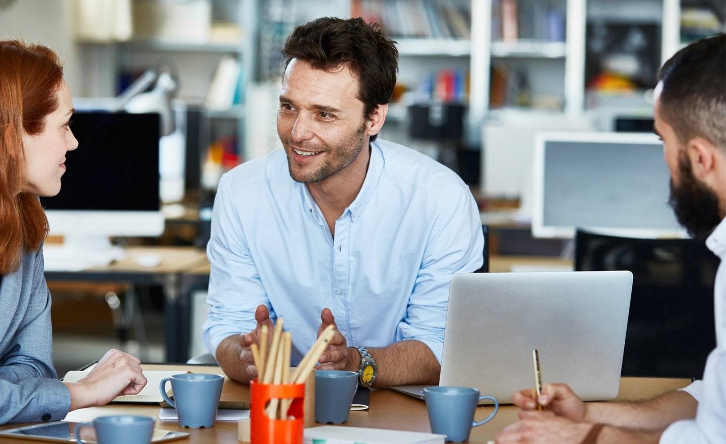 Three coworkers having a casual meeting in an open office