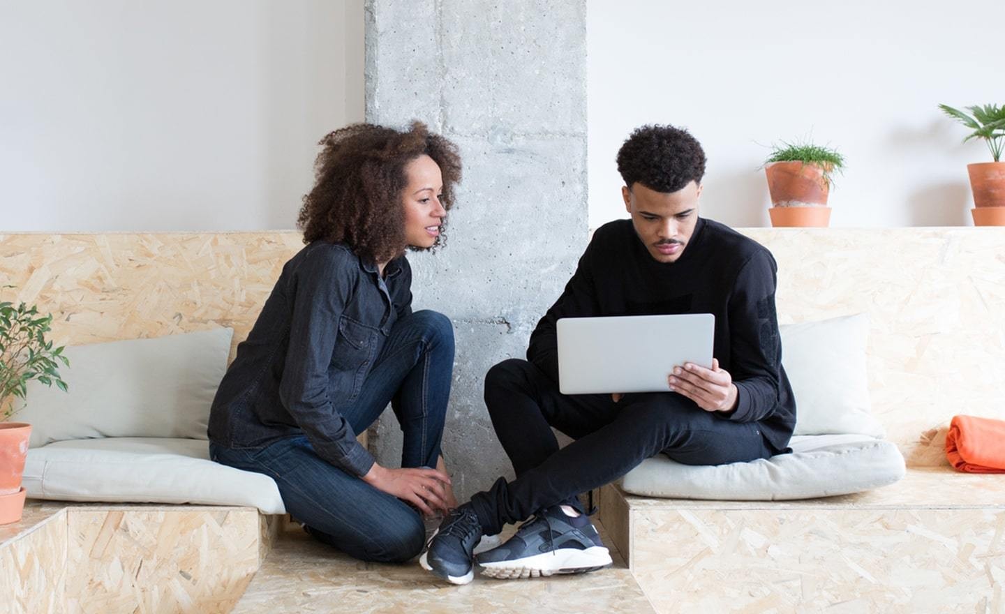 Two coworkers sitting on wood benches