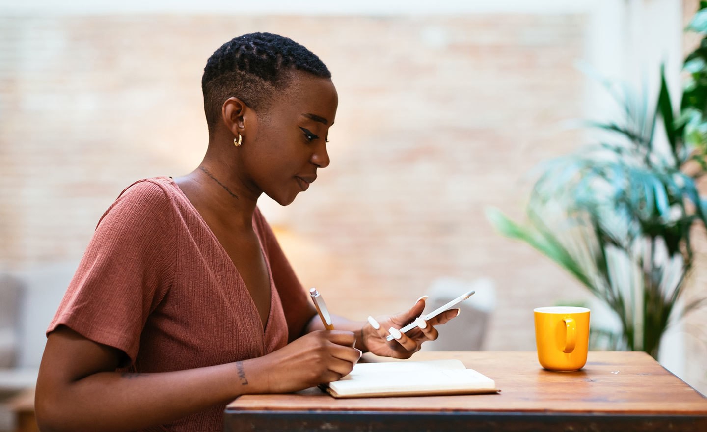 Woman taking notes during phonecall in office