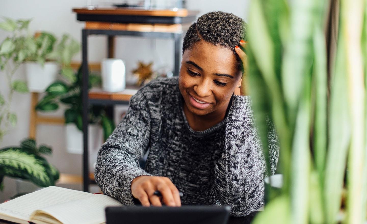 Woman taking notes off tablet