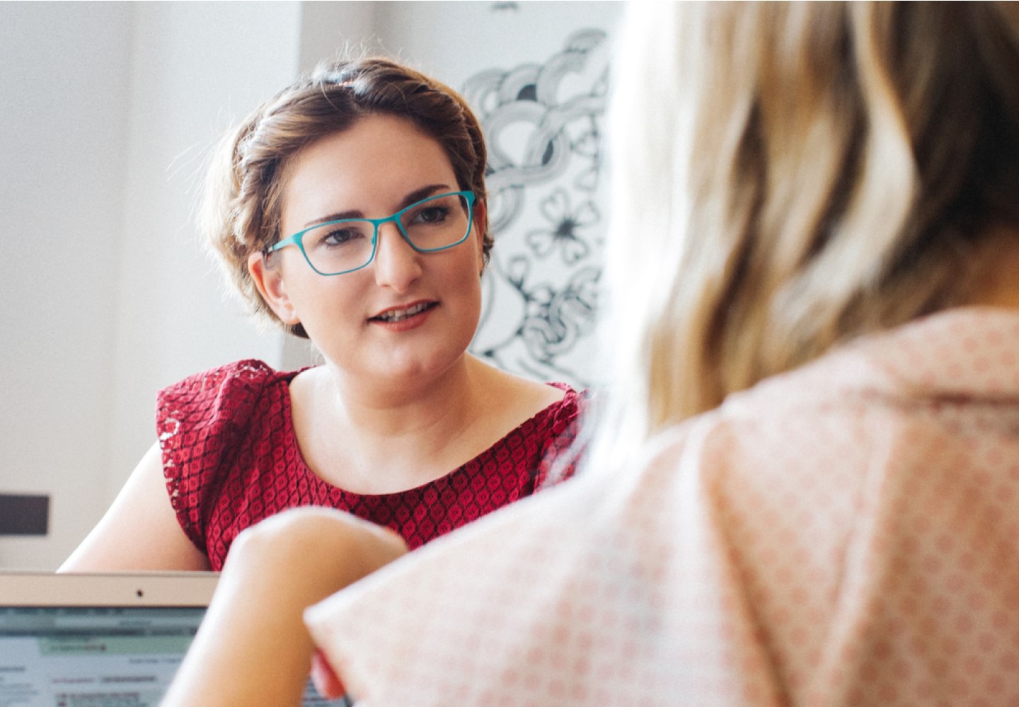 Woman wearing glasses facing colleague