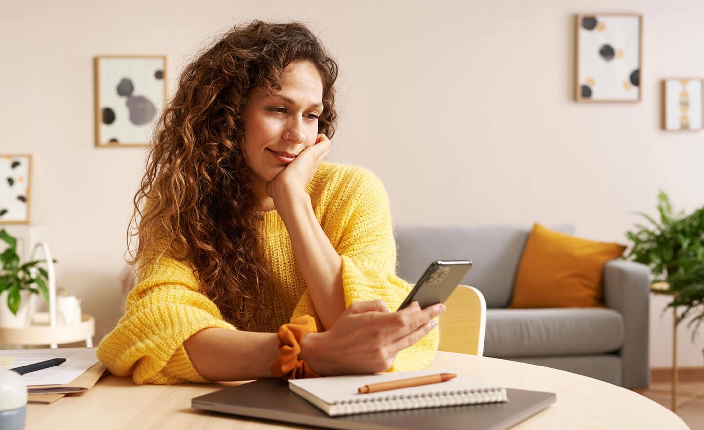 Woman working from home checking email on phone