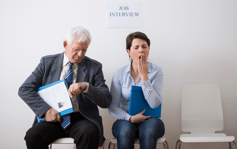 Women and man sitting next to each other with women yawning