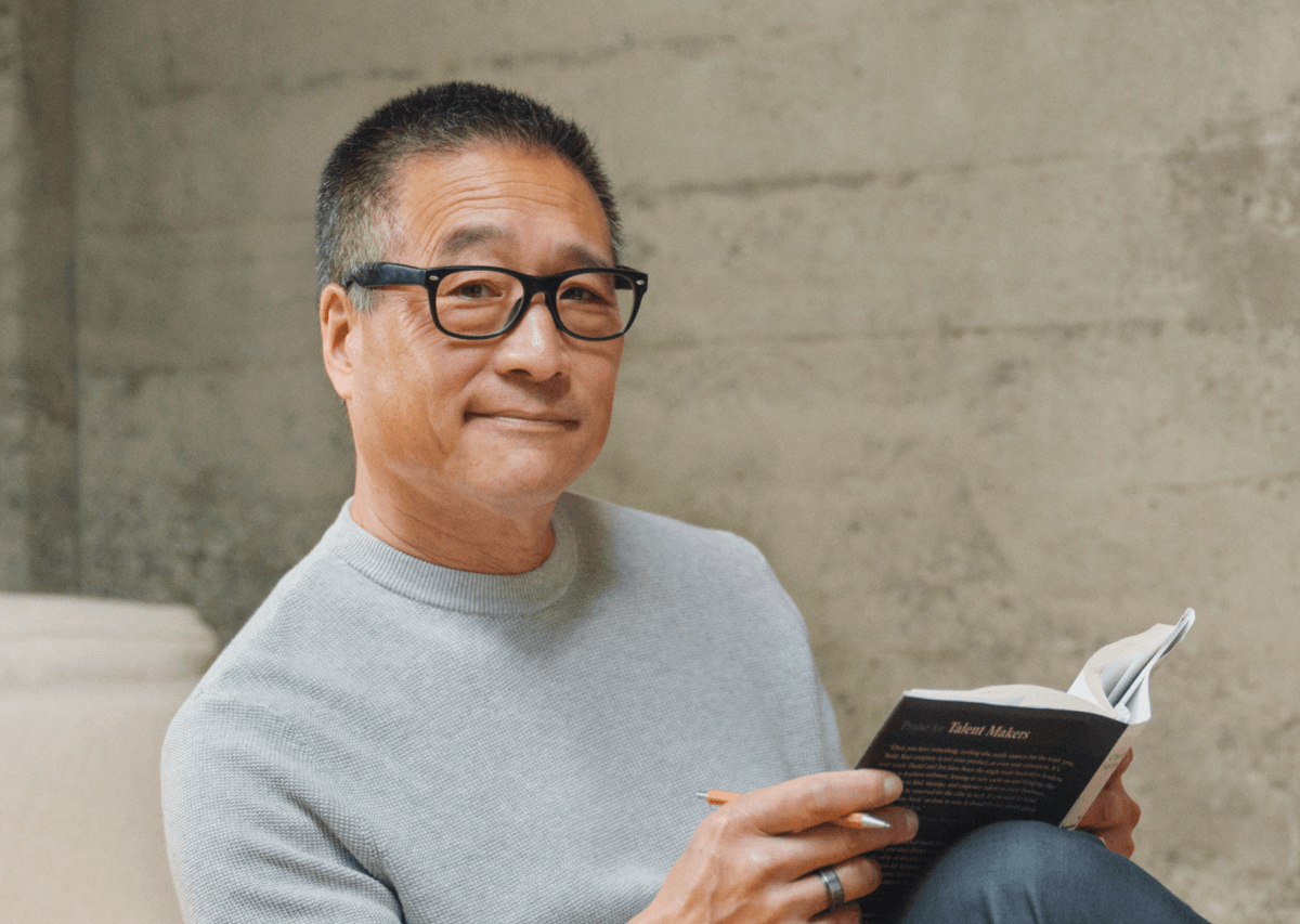 Man reading the Talent Makers book smiling