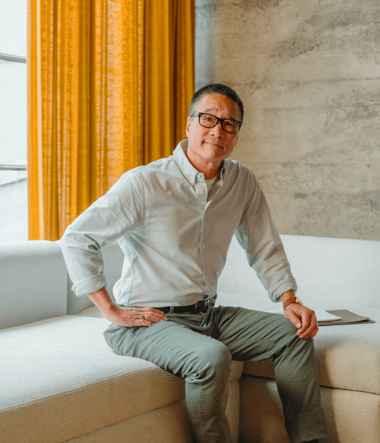 Man sitting in lounge posing with hand on hip