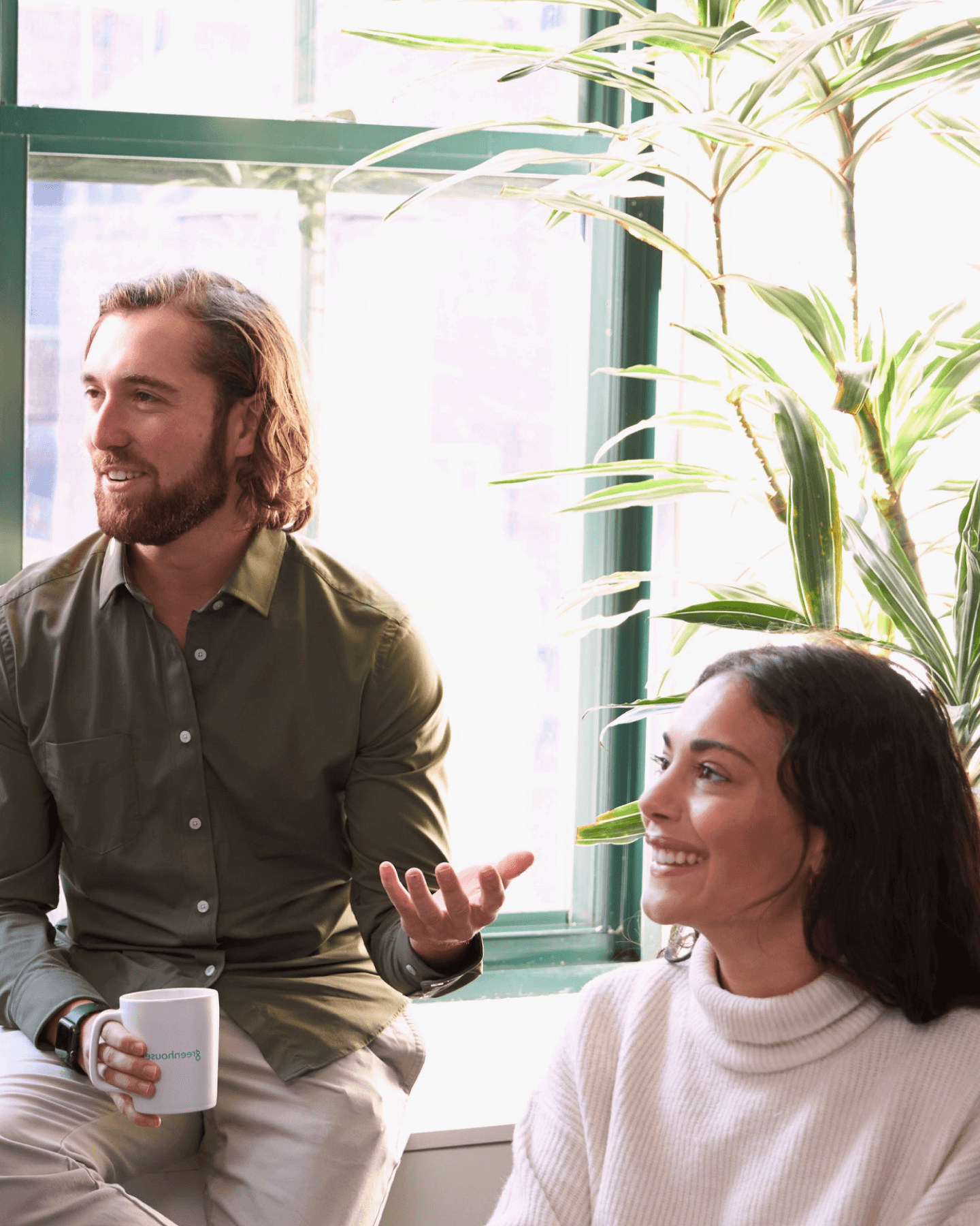 Two Greenhouse employees collaborating brightly lit office