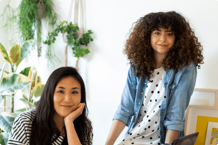 Two women posing at a desk